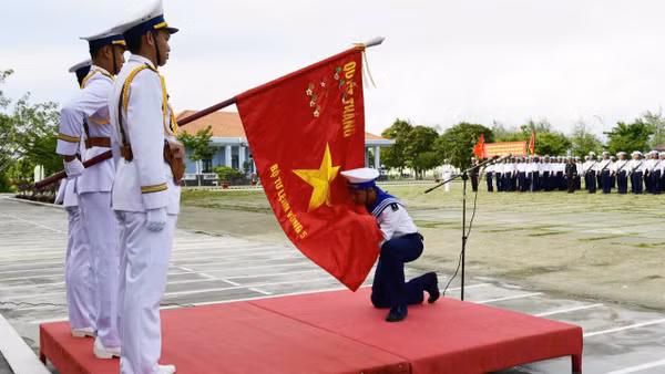 Chiến sĩ mới hôn Quân kỳ Quyết thắng. (Ảnh: Văn Định)