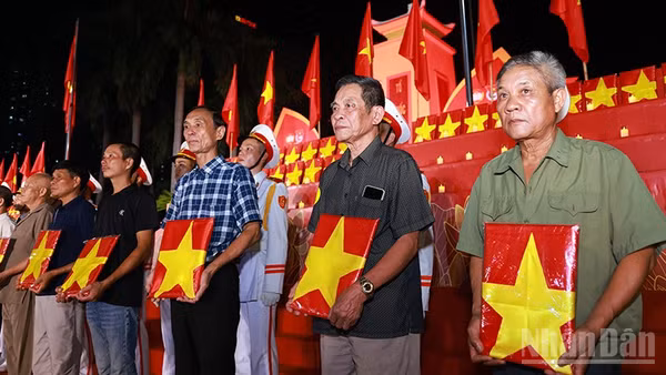 Đại diện gia đình, người thân liệt sĩ nhận di ảnh phục dựng tại buổi lễ. (Ảnh: Văn Tuyến)
