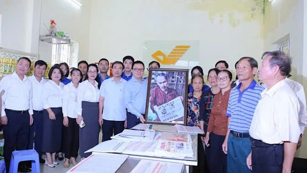 Đồng chí Lê Quốc Minh trao tặng bức tranh Bác Hồ đọc Báo Nhân Dân cho cán bộ, Đảng viên, nhân dân xã Tân Hưng tại điểm bưu điện văn hóa xã Tân Hưng (Hưng Yên).