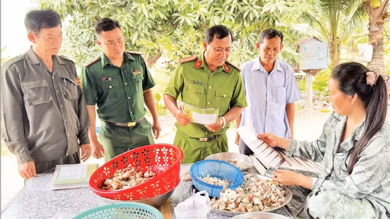Trung tá Châu Văn Nát cùng đại diện Bộ đội Biên phòng và thành viên Đội dân phòng cơ động đến nhà dân tuyên truyền phòng chống lừa đảo trực tuyến.