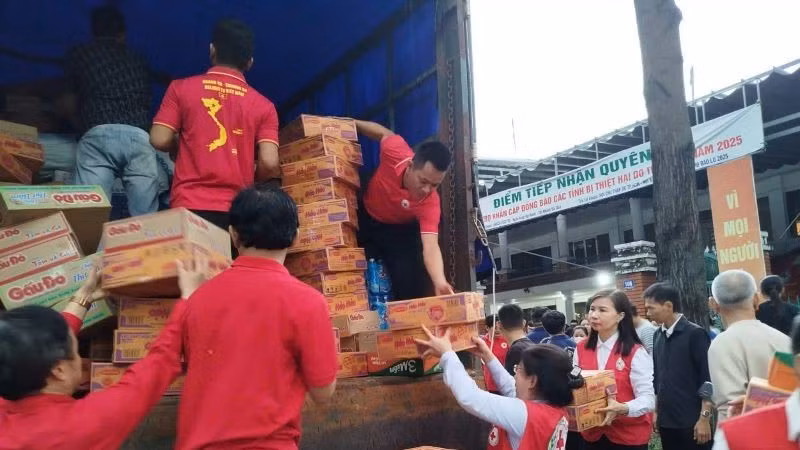 Cán bộ Hội Chữ thập đỏ Thành phố Hồ Chí Minh bốc xếp hàng hóa, thực phẩm lên xe để hỗ trợ các tỉnh bị thiên tai phía bắc. 