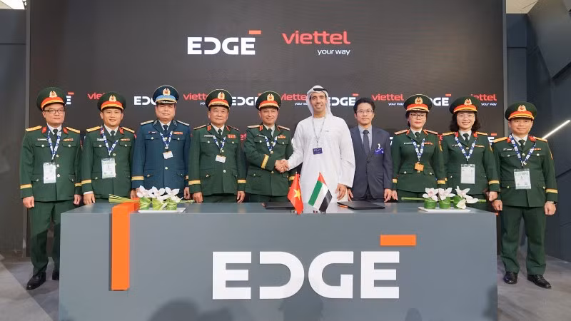 Thiếu tướng Nguyễn Đình Chiến - Phó Tổng Giám đốc Tập đoàn Viettel (thứ 5 từ trái sang) và ông Omar Al Zaabi - Chủ tịch thương mại EDGE bắt tay tại lễ ký dưới sự chứng kiến ​​của Thượng tướng Hoàng Xuân Chiến - Ủy viên Trung ương Đảng, Thứ trưởng Quốc phòng (thứ 4 từ trái sang).