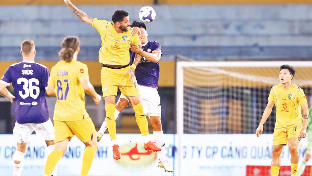 Pha tranh bóng giữa cầu thủ Hà Nội FC và Sông Lam Nghệ An (áo vàng). (Ảnh: VPF)