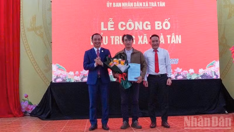 Lãnh đạo xã Trà Tân tặng hoa cho tác giả thiết kế biểu trưng xã Trà Tân.