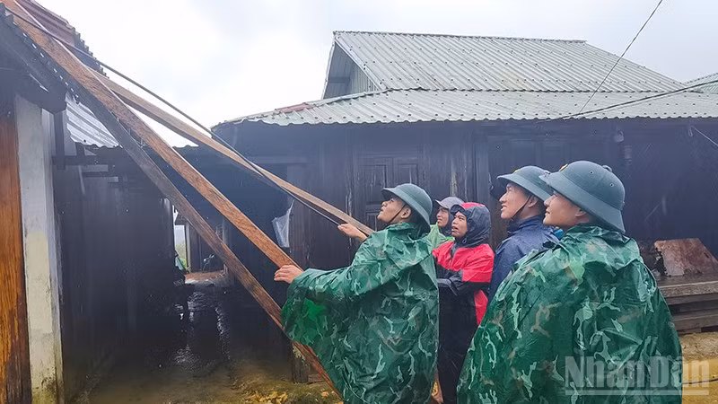 Các lực lượng chức năng hỗ trợ người dân xã Hùng Sơn lợp lại mái nhà bị tốc.