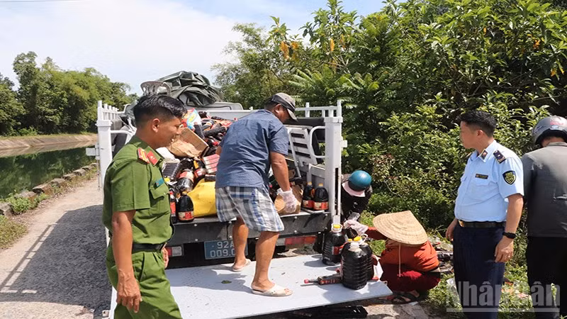 Lực lượng chức năng tỉnh Quảng Nam thu gom các sản phẩm nước mắm bị vứt bỏ để phục vụ công tác điều tra.