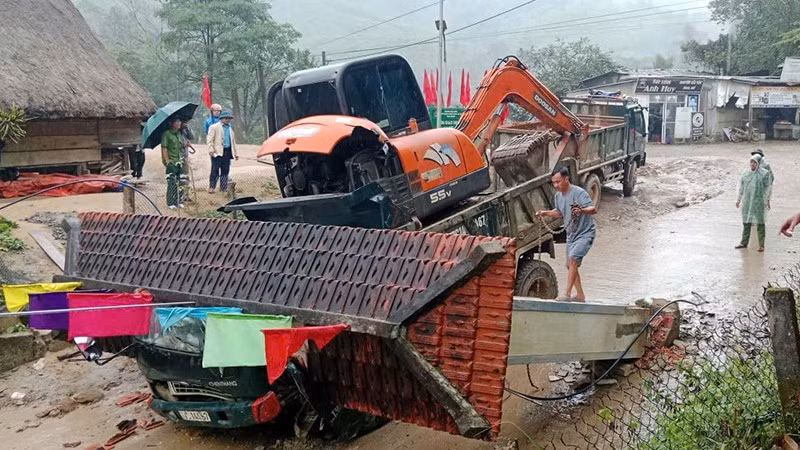 Hiện trường vụ tai nạn xe tải chở xe múc húc đổ cổng làng khiến 2 người tử vong.