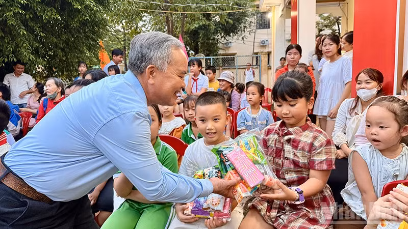 Bí thư Chi bộ kiêm Tổ trưởng Tổ dân phố Hòa Hương, phường Hương Trà Trần Thông trao quà cho các em thiếu nhi trên địa bàn. (Ảnh: ANH QUÂN)