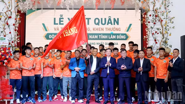 Lãnh đạo tỉnh Lâm Đồng thực hiện nghi thức trao cờ cho đội tuyển bóng đá nam tại Lễ xuất quân. (Ảnh: MAI VĂN BẢO)