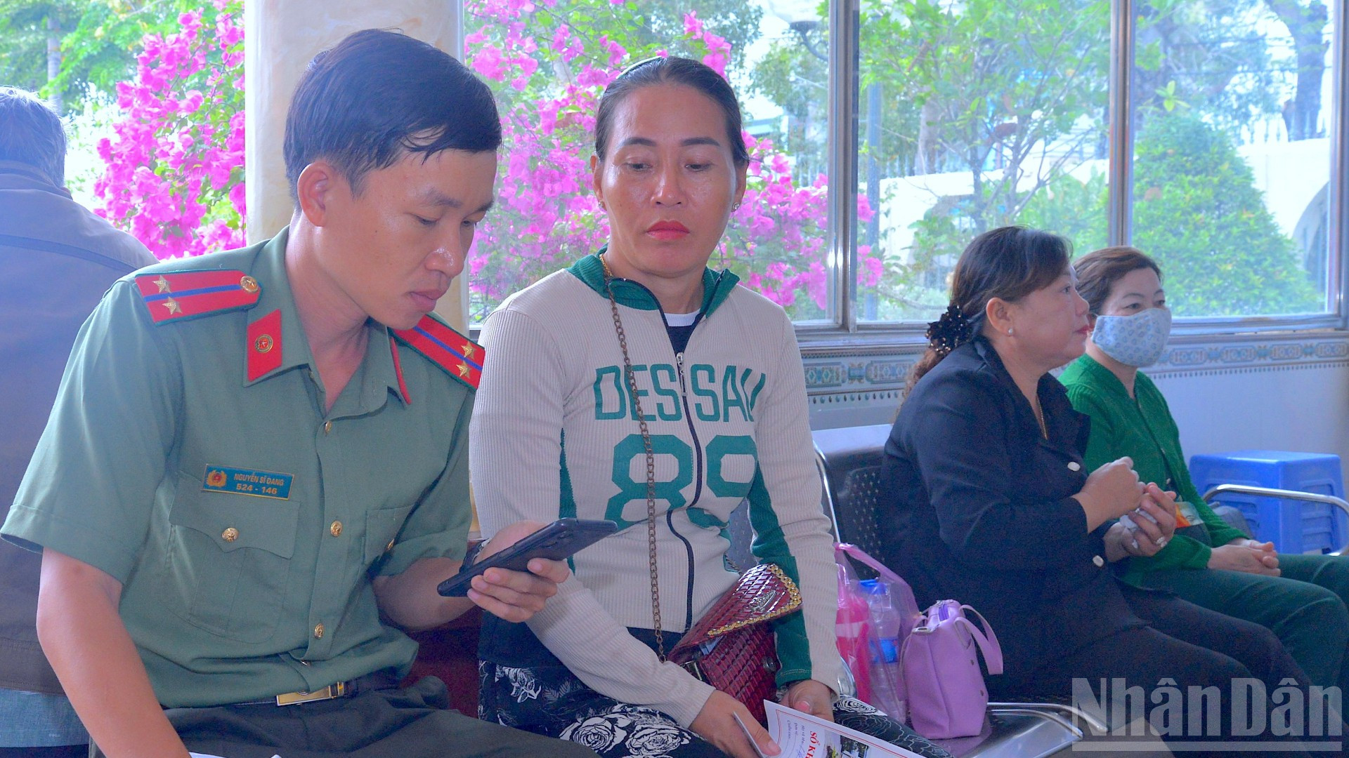 Cán bộ, đoàn viên thanh niên Bệnh viện Công an tỉnh Cà Mau hỗ trợ người dân tích hợp Sổ khám sức khỏe điện tử trên ứng dụng VNeID. (Ảnh: Hữu Đệ) ndo_br_anh-3-2918.jpg