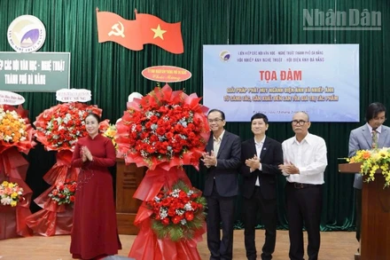 Phó Chủ tịch Ủy ban nhân dân thành phố Đà Nẵng Nguyễn Thị Anh Thi tặng hoa chúc mừng tọa đàm.