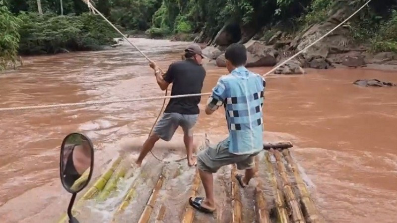 Để giữ bè không trôi theo dòng nước, người dân phải dùng sức bám chặt vào dây thừng dòng dọc ngang suối. 