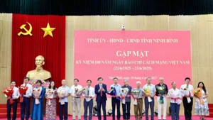 Đồng chí Đoàn Minh Huấn, Bí thư Tỉnh ủy Ninh Bình trao biểu trưng và tặng hoa chúc mừng các đồng chí lãnh đạo, nguyên lãnh đạo các cơ quan báo chí của tỉnh. (Ảnh: MINH QUANG)