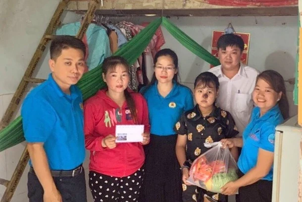 Cán bộ công đoàn tặng quà con công nhân có hoàn cảnh khó khăn tại khu trọ phường An Bình (thành phố Dĩ An, Bình Dương). (Ảnh: HUYỀN TRANG) 