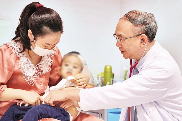Phó Giáo sư, Tiến sĩ, Bác sĩ Vũ Chí Dũng khám cho bé Quang Thanh. 