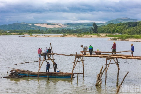 Người dân xây dựng lại cầu gỗ Ông Cọp sau khi công trình bị lũ cuốn đi vào tháng 11 vừa qua.