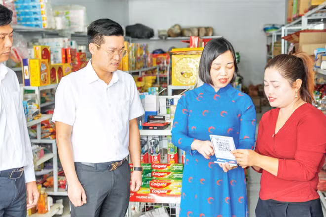 Các cán bộ của Co-opBank Phú Thọ hướng dẫn hộ kinh doanh tiếp cận dịch vụ số của ngân hàng.