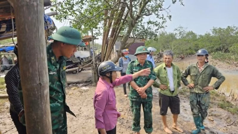 Đồn Biên phòng Cảng cửa khẩu Diêm Điền phối hợp người dân bàn bạc hướng tìm kiếm bà bị lạc trong rừng ngập mặn. (Ảnh: Bộ đội biên phòng cung cấp)