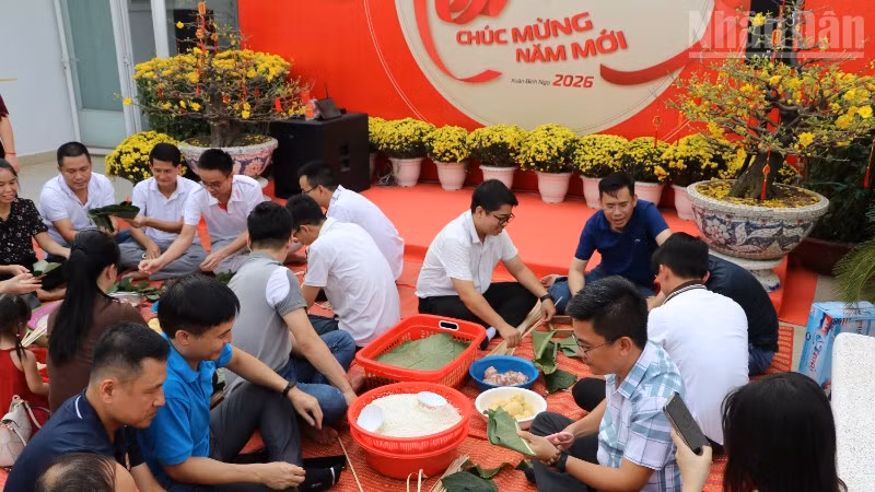 Đông đảo cán bộ, nhân viên người Việt và người Campuchia của Công ty Metfone tham gia hoạt động cùng nhau gói bánh chưng ngày Tết. (Ảnh: HUY VŨ)