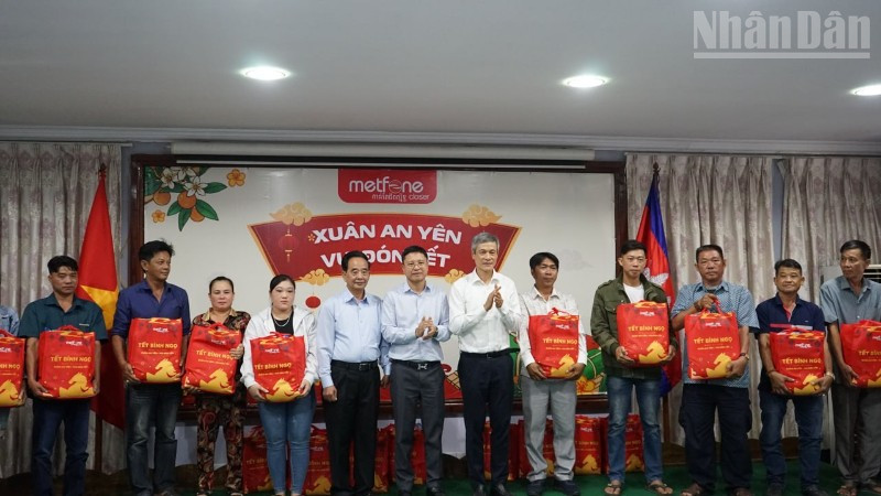 Đại sứ Việt Nam tại Campuchia Nguyễn Minh Vũ cùng đại diện Ban tổ chức trao tặng quà Tết cho bà con gốc Việt có hoàn cảnh khó khăn. (Ảnh: ĐINH TRƯỜNG)