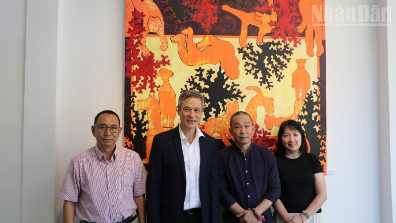 Đại sứ Việt Nam tại Campuchia Nguyễn Minh Vũ (áo vest đen) đến với triển lãm của họa sĩ Bùi Hoàng Dương (sơ-mi đen). (Ảnh: HUY VŨ)