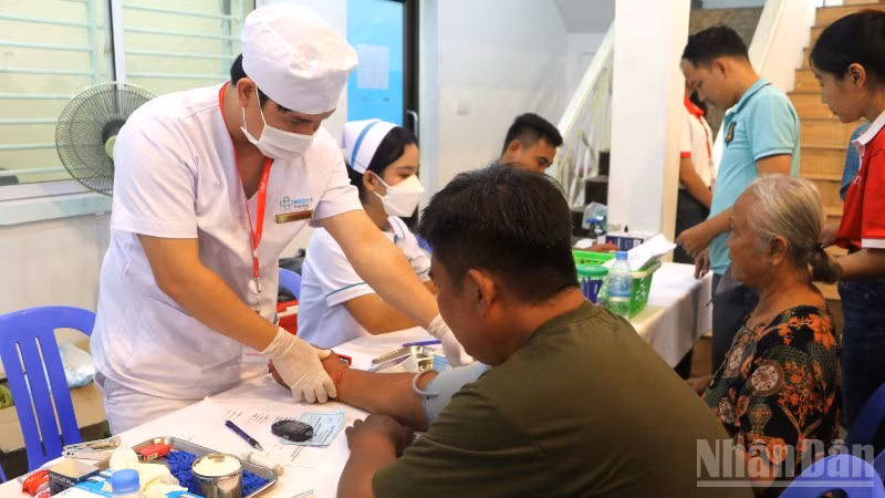 Các y, bác sĩ ân cần khám bệnh cho người dân. (Ảnh: HUY VŨ)
