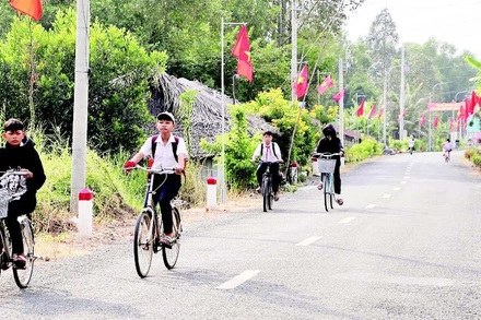 Người dân xã Vĩnh Viễn treo cờ chào mừng Đại hội Đảng bộ xã nhiệm kỳ 2025-2030.