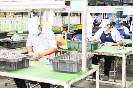Công nhân làm việc tại Công ty trách nhiệm hữu hạn JUKI (chuyên sản xuất linh kiện máy khâu) tại Khu chế xuất Tân Thuận, phường Tân Thuận, Thành phố Hồ Chí Minh. (Ảnh THẾ ANH)