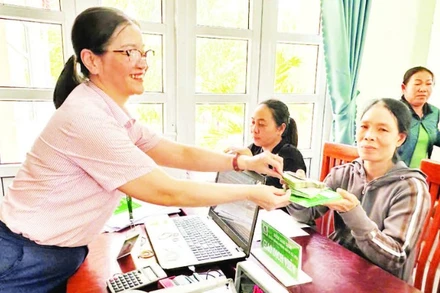 Nhân viên tín dụng Ngân hàng Chính sách xã hội Ninh Phước (Khánh Hòa) giải ngân vốn vay cho người dân đầu tư phát triển kinh tế hộ gia đình.