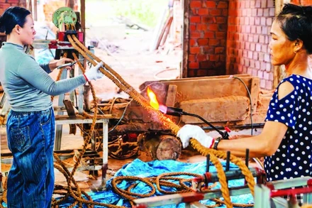 Công nhân Công ty TNHH Ngọc Chung Coir hoàn thiện sản phẩm dây thừng trang trí trước khi xuất xưởng. (Ảnh MỸ HÀ)