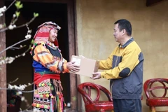 Nhân viên bưu điện chuyển phát bưu phẩm đến tay người dân.