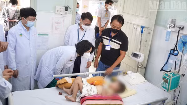 Đoàn công tác của Bộ Y tế thăm bệnh nhi điều trị tay chân miệng tại Bệnh viện Nhi đồng 2. (Ảnh: KHANG ANH)