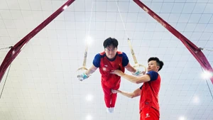 Huấn luyện viên Trương Minh Sang hỗ trợ vận động viên trong bài tập vòng treo.
