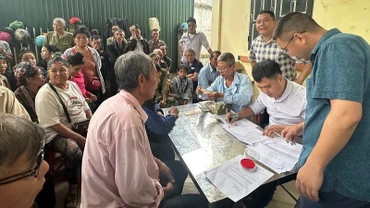 Cán bộ văn phòng Công ty cổ phần Cao-su Điện Biên chi trả tiền góp đất đến người dân trên địa bàn xã Mường Pồn, tỉnh Điện Biên.