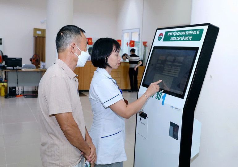 Hướng dẫn người bệnh đăng ký khám, chữa bệnh trên Kiosk tại Bệnh viện đa khoa Ba Vì (Hà Nội). (Ảnh: Nhật Minh) 2.jpg
