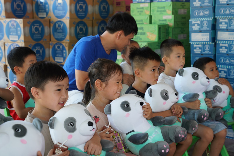 Nỗi sợ những ngày lũ dâng chưa tan, nhưng nụ cười đã hé lại khi các em được các cô chú Vinamilk đến tặng sữa, tặng quà. (Ảnh: Tịnh Không) anh-05a.jpg