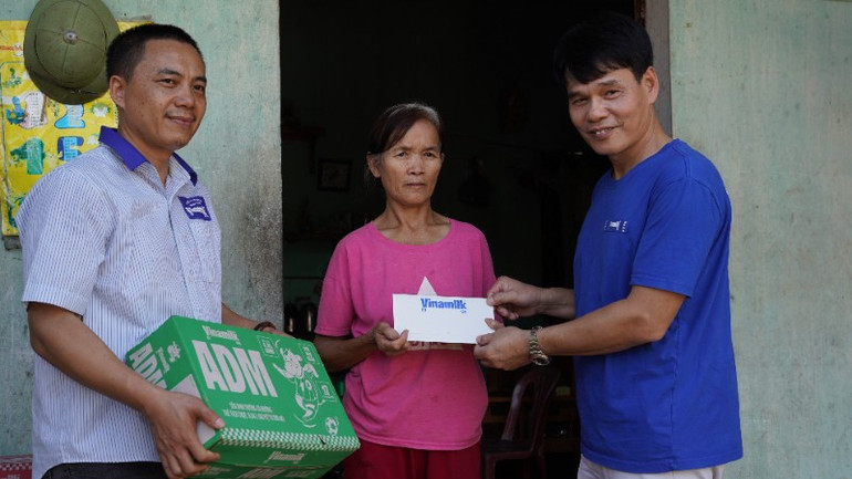 Đại diện Vinamilk, ông Phạm Tuyên, Giám đốc chi nhánh Hà Nội trao quà động viên hộ dân khó khăn tại xã Vân Nham, Lạng Sơn. (Ảnh: Tịnh Không) anh-06a-832.jpg