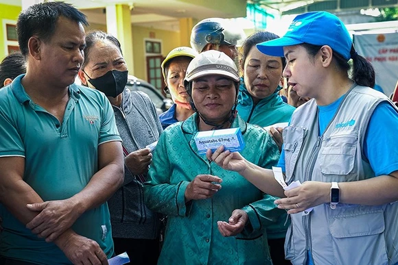Cán bộ của UNICEF với người dân ở vùng bị ảnh hưởng bởi lũ lụt, sạt lở đất do hoàn lưu của bão số 3. (Ảnh UNICEF)