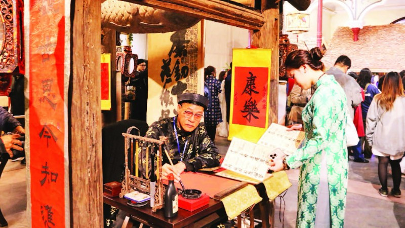 Du khách thích thú với hình ảnh ông đồ bên mực tàu, giấy đỏ trong phố cổ.