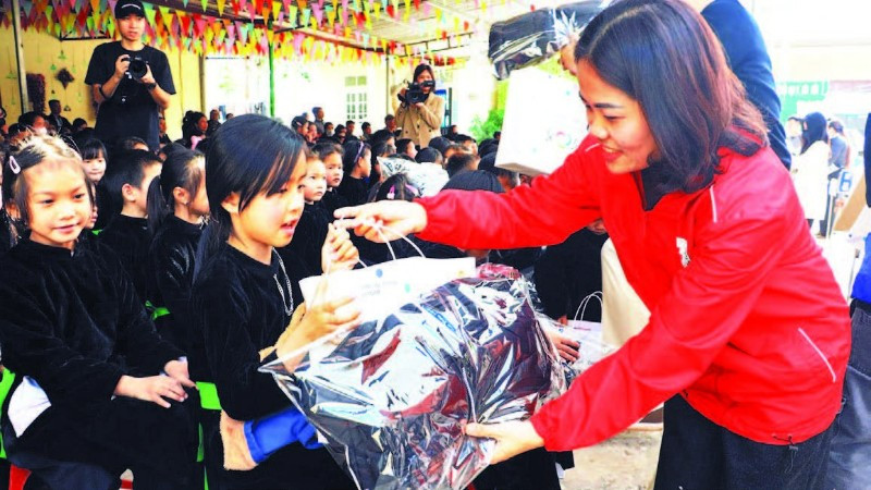 Lãnh đạo Hội Chữ thập đỏ trao quà cho các học sinh trên địa bàn. (Ảnh LƯƠNG THẢO)