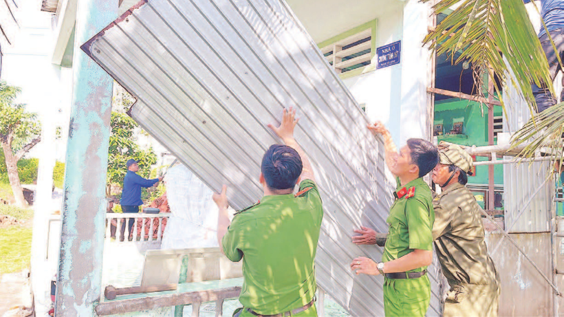 Lực lượng tình nguyện Công an tỉnh Cà Mau giúp người dân tháo dỡ nhà tạm, nhà dột nát.