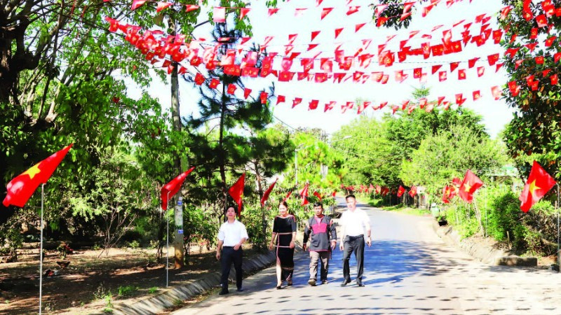 Các tuyến đường dẫn vào buôn Tuôr, xã Hòa Phú rợp đỏ màu cờ Tổ quốc chào mừng Đại hội XIV của Đảng.