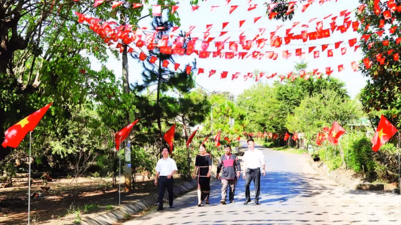 Các tuyến đường dẫn vào buôn Tuôr, xã Hòa Phú rợp đỏ màu cờ Tổ quốc chào mừng Đại hội XIV của Đảng.