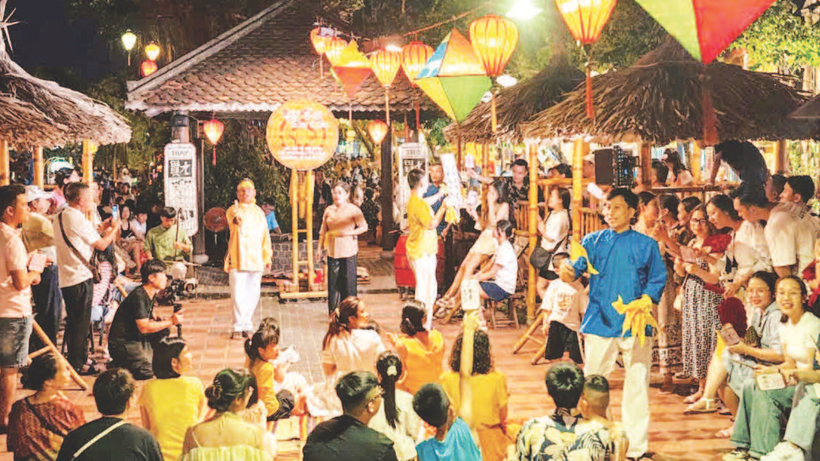 Menschen und Touristen hören in Hoi An Bai Chois Gesang zu.