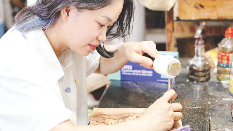 Chị Ngô Phương Dung tạo hình trên tấm da mộc.