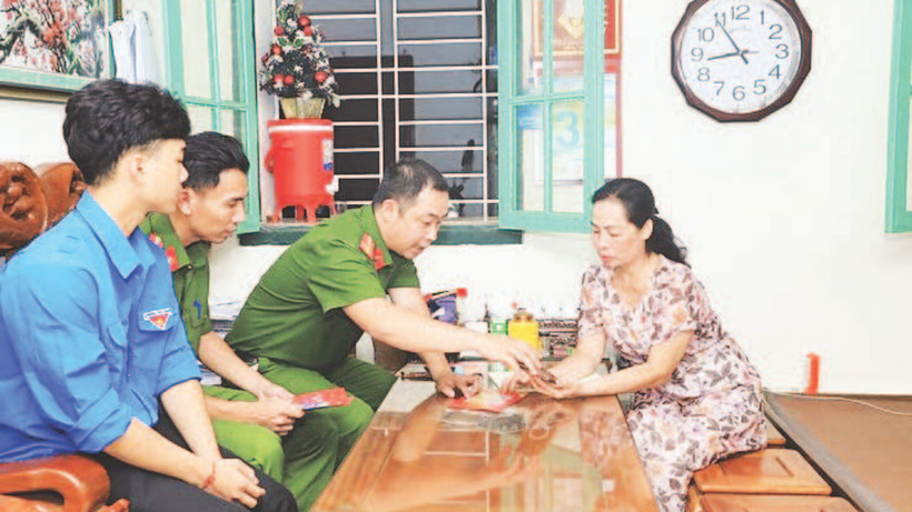 Cán bộ công an và đoàn viên, thanh niên phường Cửa Nam hướng dẫn người dân sử dụng ứng dụng dịch vụ hành chính công. (Ảnh LÊ HẢI)