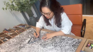 Họa sĩ Hoàng Thị Thu Hà miệt mài bên tác phẩm.