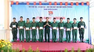 Đại tá Cao Minh Tâm, Phó Chính ủy Bộ Chỉ huy quân sự tỉnh Kiên Giang trao tặng quà cho cán bộ, chiến sĩ đại đội 6, Tiểu đoàn 519 có hoàn cảnh khó khăn. (Ảnh: PHƯƠNG VŨ).