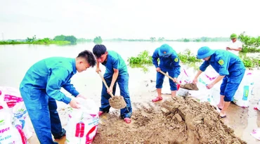 Lực lượng xung kích xã Phú Nghĩa tham gia đắp đê chống tràn. (Ảnh KIM THOA)