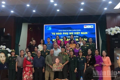 Gia đình Anh hùng Lực lượng vũ trang nhân dân-Liệt sĩ Lê Văn Dỵ trao tặng di ảnh và cuốn sách "Đâu có giặc là ta cứ đi" cho Bảo tàng Phụ nữ Việt Nam.